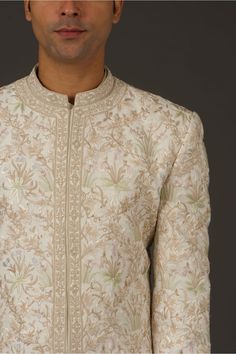 Editor's Note Ivory Matka Silk Sherwani With Silk Lining Has Resham & Hand Embroidery Work Note: Churidar worn by model is for styling purposes. Color: Ivory Fabric: Silk Components: Sherwani Care: Dry Clean Only About the Designer Rohit Bal is intensely concerned with design as an art form. The designer draws on history, fantasy and folklore to create masterpieces that are desired by discerning aficionados around the globe. Rohit has a deep understanding of the psyche of the fashion world and i Elegant Floral Embroidered Churidar For Weddings, Diwali Sherwani With Floral Embroidery In Raw Silk, Designer Unstitched Sets With Floral Embroidery, Designer Straight Kurta With Resham Embroidery, Designer Resham Embroidery Straight Kurta, Transitional Bandhgala With Floral Embroidery In Raw Silk, Designer Raw Silk Bandhgala With Floral Embroidery, Embroidered Straight Kurta Bandhgala For Reception, Floral Embroidered Churidar For Reception And Festivals