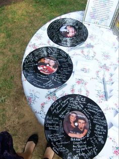 three plates with pictures on them sitting on top of a table covered in flowers and people's names