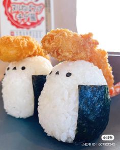 two sushi balls with rice and chicken on them