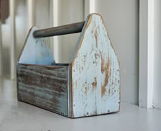 an old wooden house shaped box sitting on the floor