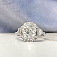 an antique style diamond ring with baguetts and side stones