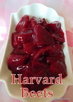 a white bowl filled with beets on top of a pink flowered table cloth