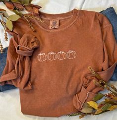 Fall Pumpkin Burnt Orange Comfort Colors Long Sleeve Shirt Welcome autumn with cozy style in our Fall Pumpkin Burnt Orange Comfort Colors Long Sleeve Shirt. Designed for both comfort and seasonal flair, this shirt is perfect for crisp fall days, pumpkin patch adventures, and festive gatherings. Key Features: Festive Design: Features a delightful pumpkin graphic with intricate autumn details, capturing the essence of fall. The design adds a touch of whimsy and seasonal charm, making it a must-hav Casual Brown T-shirt For Fall, Cozy Orange Crew Neck Top, Soft-washed Casual T-shirt For Fall, Trendy Brown Tops For Fall, Cozy Fit Long Sleeve Cotton Top, Cozy Fit Cotton Long Sleeve Top, Brown Crew Neck Top For Fall, Casual Burnt Orange Tops For Fall, Burnt Orange Long Sleeve Winter Top