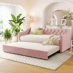 a living room filled with furniture and a pink couch