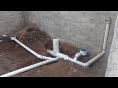 pipes are lined up on the ground in an unfinished room with brick walls and concrete flooring