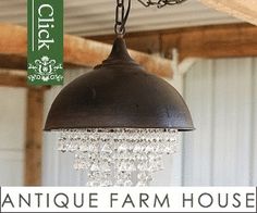 an antique farm house chandelier hanging from the ceiling in front of a shed