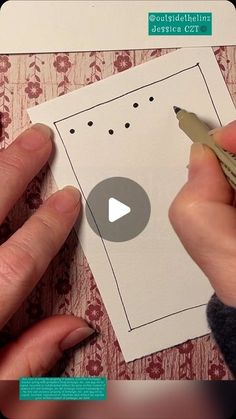 a person is cutting out a card with a pen and paper clipping on it