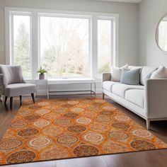 a living room filled with furniture and a large rug on top of a hard wood floor