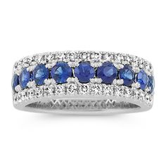 This 14-karat white gold band features traditional blue natural sapphires along the center with sparkling natural diamond borders. It offers a beautiful  bold look  making a gorgeous anniversary gift  wedding band  or daily accessory. Classic Sapphire Ring With Pave Setting, Classic Sapphire Rings With Pave Setting, Classic Blue Rings With Pave Setting, White Gold Sapphire Ring With Pave Setting, Blue Diamond Ring With Pave Setting For Anniversary, Blue Brilliant Cut Eternity Band For Anniversary, Classic Sapphire Ring With Pave Setting For Anniversary, Formal Sapphire Diamond Ring With Half Eternity Setting, Formal Sapphire Diamond Ring With Half Eternity