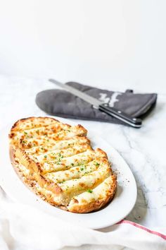 a white plate topped with food next to a pair of scissors and an oven mitt