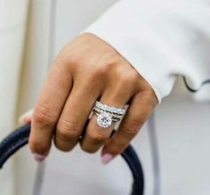 a close up of a person's hand holding a ring