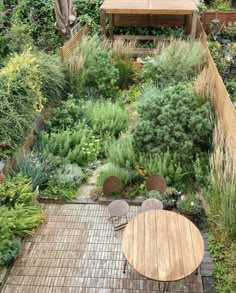 a wooden table sitting in the middle of a garden