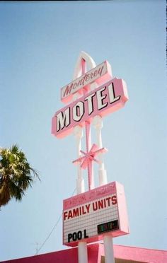 the neon motel sign is pink and white