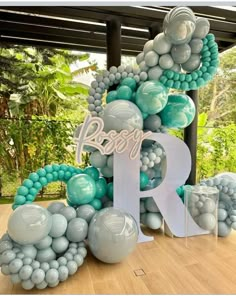 the letters r and person are made out of balloons in shades of blue, grey and white