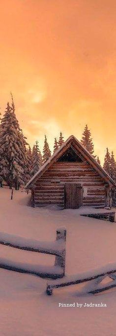 an old log cabin sits in the middle of a snowy field with trees on either side