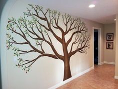 a tree painted on the side of a wall in a room with tile flooring