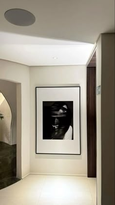 a black and white photo hanging on the wall next to a framed art piece in a hallway