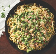 a bowl filled with pasta and peas on top of a table