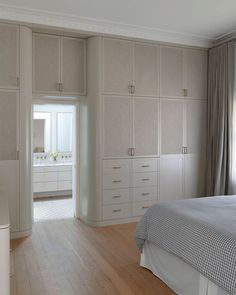 a bedroom with white furniture and wooden floors