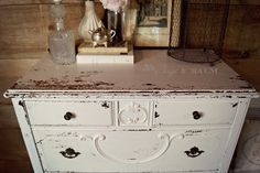 an old dresser has been painted white with brown glaze on the top and bottom