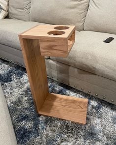 a wooden table sitting on top of a carpeted floor next to a white couch