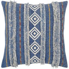 a blue and white pillow with fringes on it