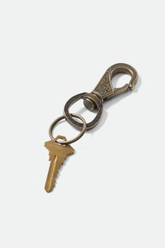 an antique keychain with two keys hanging from it's side on a white surface