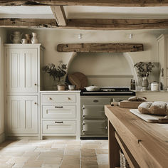 a kitchen with an oven, stove and counter tops in white painted wood beams on the ceiling