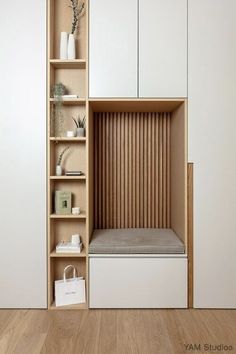 an empty shelf in the corner of a room with white cupboards and wooden flooring