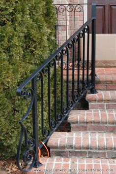 a wrought iron stair rail on brick steps