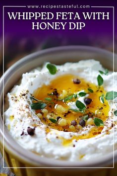 whipped feta with honey dip in a bowl on top of a wooden table and purple background