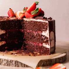 there is a chocolate cake with strawberries on the top and one slice cut out