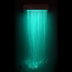 a green shower head in the dark