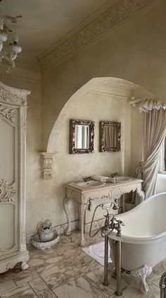 an ornate bathroom with a claw foot tub and marble counter tops, along with two sinks