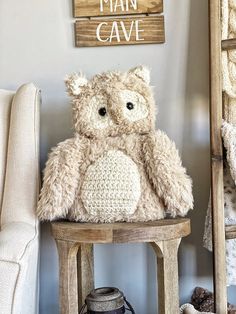 a teddy bear sitting on top of a wooden stool next to a sign that says man cave