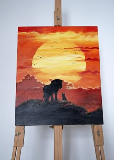 an easel with a painting of a lion on it and the sun in the background