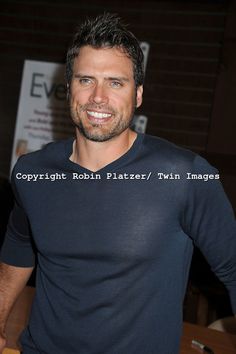 a man standing in front of a wooden table