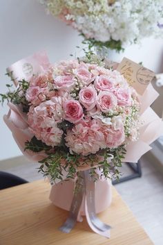 a bouquet of pink flowers sitting on top of a table