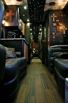 the inside of a bus with leather couches and cross decorations on the wall above