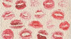 red lipstick kisses drawn on paper with white crumbs and some other things in the background