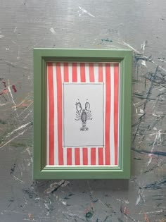 a green frame with a red and white striped pattern on it, holding an image of a crab