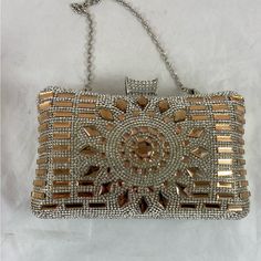 This Beautiful Rhinestone Evening Bag/Clutch Is Perfect For Those Special Occasions. With A Detachable Gold Tone Chain Strap And Rhinestone Snap Closure Perfect For Cell Phone, Key, Money And Small Compact. The Clutch Is 8 Inches Wide. 5.5 Inches Tall From Clasp To Bottom Of The Bag. 2.5 Inches From Front To Back Chain Drop Is 7 Inches. It Comes In Its Original Box. It Is In New Condition. Please See All Of The Photos. Luxury Silver Bedazzled Bags, Silver Bedazzled Evening Bag For Events, Luxury Silver Crystal Bag, Luxury Crystal Silver Bag, Silver Rectangular Bags With Bling, Silver Bling Clutch For Events, Silver Crystal Clutch With Bling, Silver Crystal Rectangular Bag, Silver Embellished Crystal Bag