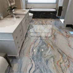 a bathroom with marble flooring and white fixtures in the bathtub, sink, and toilet