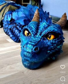 a blue dragon head sitting on top of a wooden floor