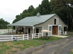 a barn with a horse in the yard