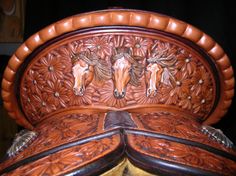 an intricately carved leather chair with horses on it