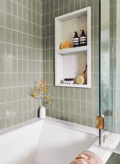 a white bath tub sitting under a bathroom mirror