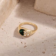 Immerse yourself in the allure of nature with our Green Enamel Blossom Signet Ring. This enchanting piece features a green enamel base, intricately paved with flower-shaped sparkling stones, creating a harmonious blend of elegance and botanical charm. Whether worn as a standalone statement piece or paired with other favorites, the Green Enamel Blossom Signet Ring is a celebration of natural beauty and a unique addition to your jewelry collection. - Made in 14k solid gold - Decorated with handset Emerald Signet Ring, Curve Ring, Tamil Wedding, Bezel Necklace, Signet Rings, Bear Necklace, Gold Decor, Green Enamel, Ring Collections