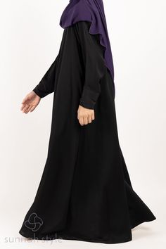 Our Girls Simplicity Umbrella Abaya is designed with a stunning princess cut for a modest and flowing fit. The abaya features a pleated neck with a diagonal zipper from the shoulder to the underarm and includes zippered side pockets for added convenience. The abaya is made of our premium crepe which is excellent quality, medium weight, and suitable for all seasons. The fabric has a smooth and slightly silky feel to it, allowing it to drape beautifully and making it perfect for everyday wear or special occasions. Elegant Black Abaya With Modesty Panel, Modest Black Abaya With Long Sleeves, Modest Black Long Sleeve Abaya, Modest Long Sleeve Black Abaya, Long Black Abaya For Eid, Black Long Abaya, Modest Black Long Sleeve Khimar, Modest Long Sleeve Black Khimar, Black Abaya With Modesty Panel For Eid