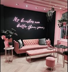 a living room with pink furniture and neon lights on the wall, along with black walls